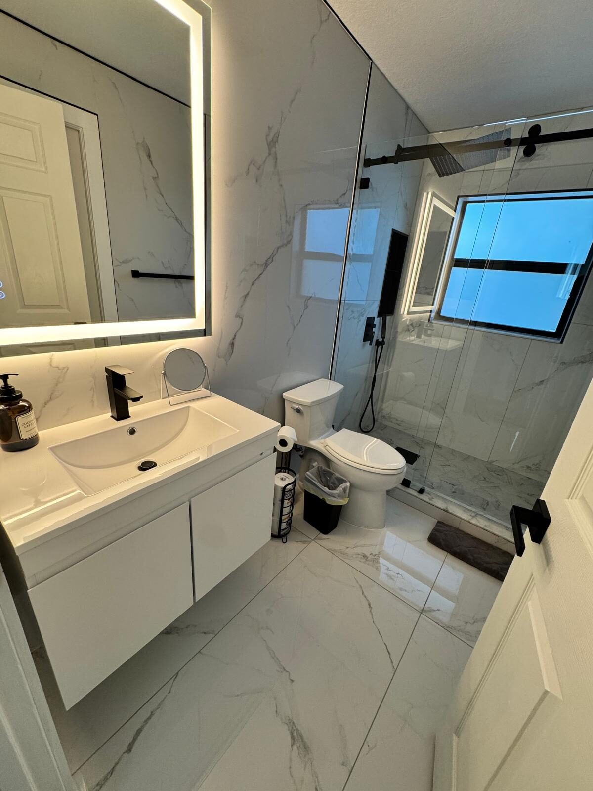 Sparkling marble bathroom with glass shower and polished vanity
