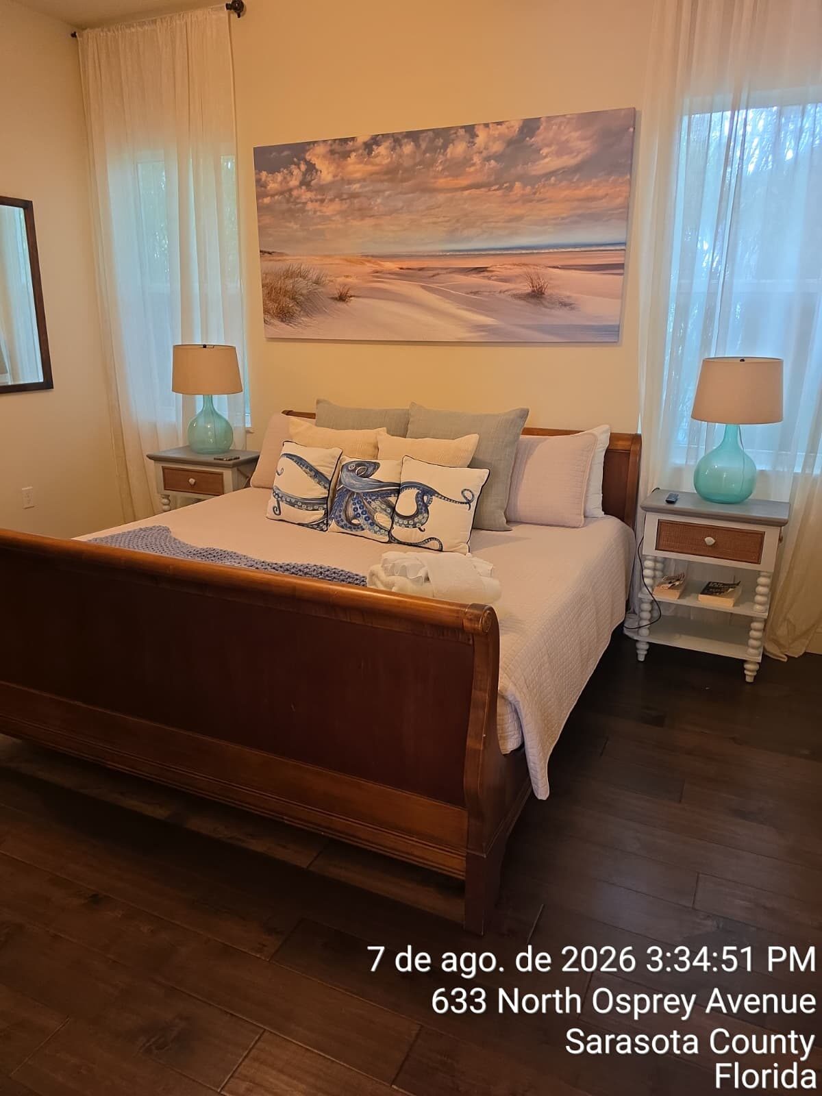Coastal bedroom with crisp white bedding and clean hardwood floors